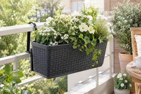 Jardinière Kreher anthracite à décor rotin, suspendue à une rambarde et garnie de fleurs.